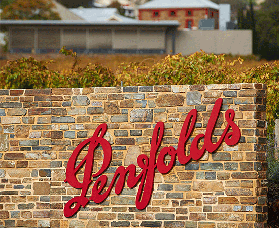 Penfolds red logo on brick fence. Entrance sign to Magill Estate Winery